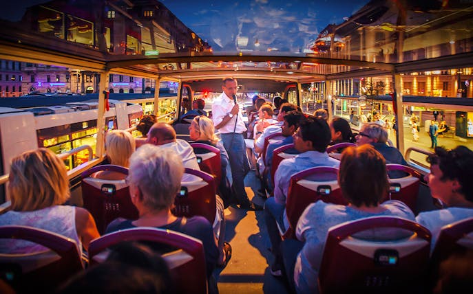 Guide speaking to tourists on open-top bus during Berlin Lights Festival.
