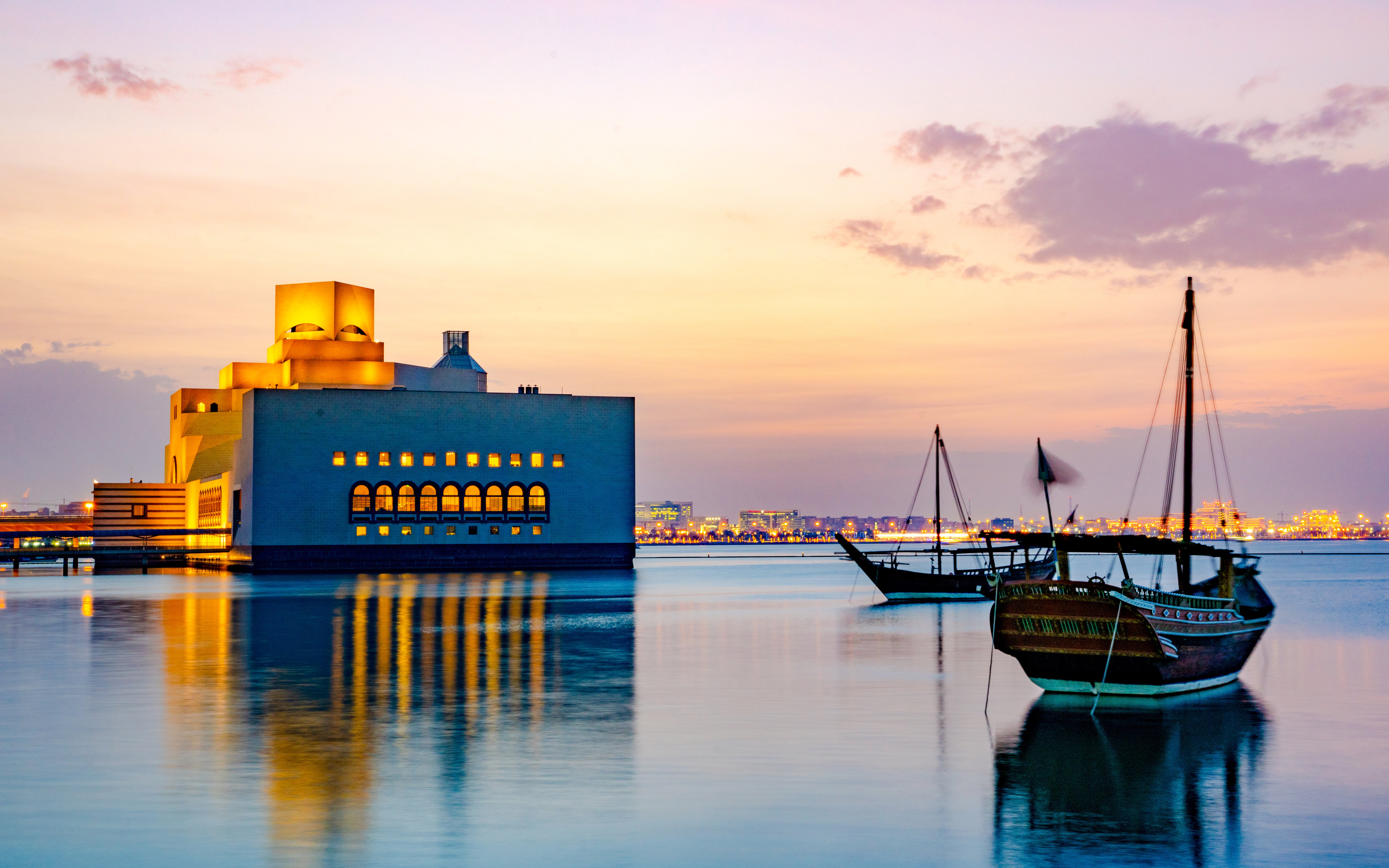 Museum of Islamic Art and traditional boats at sunset, Doha Corniche.