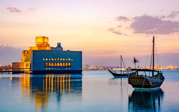 Museum of Islamic Art and traditional boats at sunset, Doha Corniche.