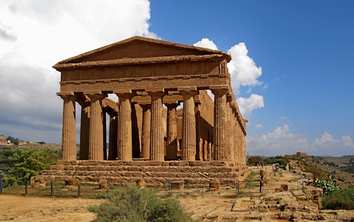Valley of Temples, Agrigento, ancient Greek temple with columns under blue sky.