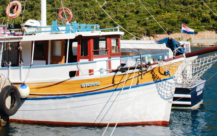 Boat docked at Dubrovnik port during Blue Cave Swim Stop & Three Island Boat Tour.