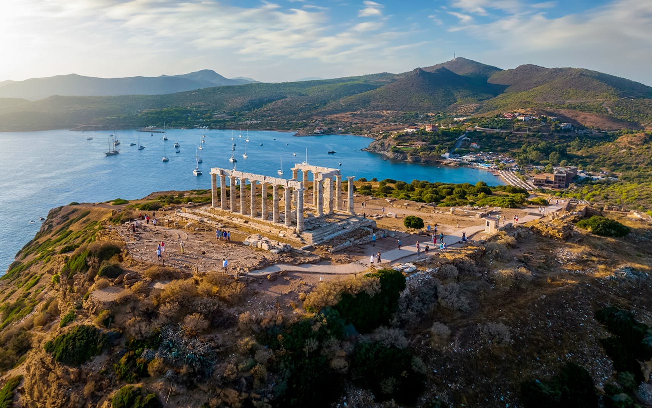 Temple of Poseidon at Cape Sounion overlooking the Aegean Sea with distant hills.