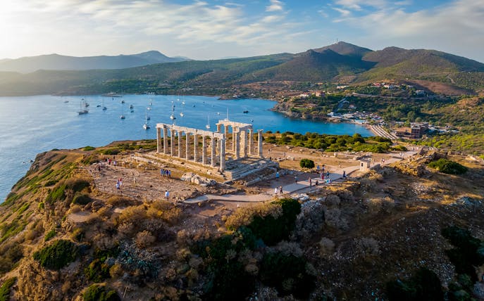 Temple of Poseidon at Cape Sounion overlooking the Aegean Sea with distant hills.