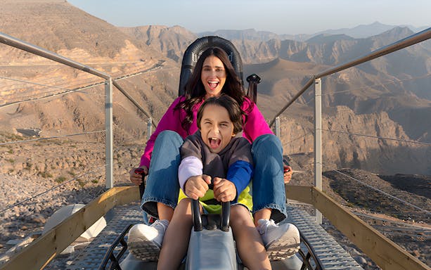 Mother and child enjoying Jais Sledder ride in Ras Al Khaimah mountains.