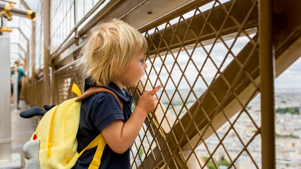 Kid looking at Paris city from Eiffel Tower Summit