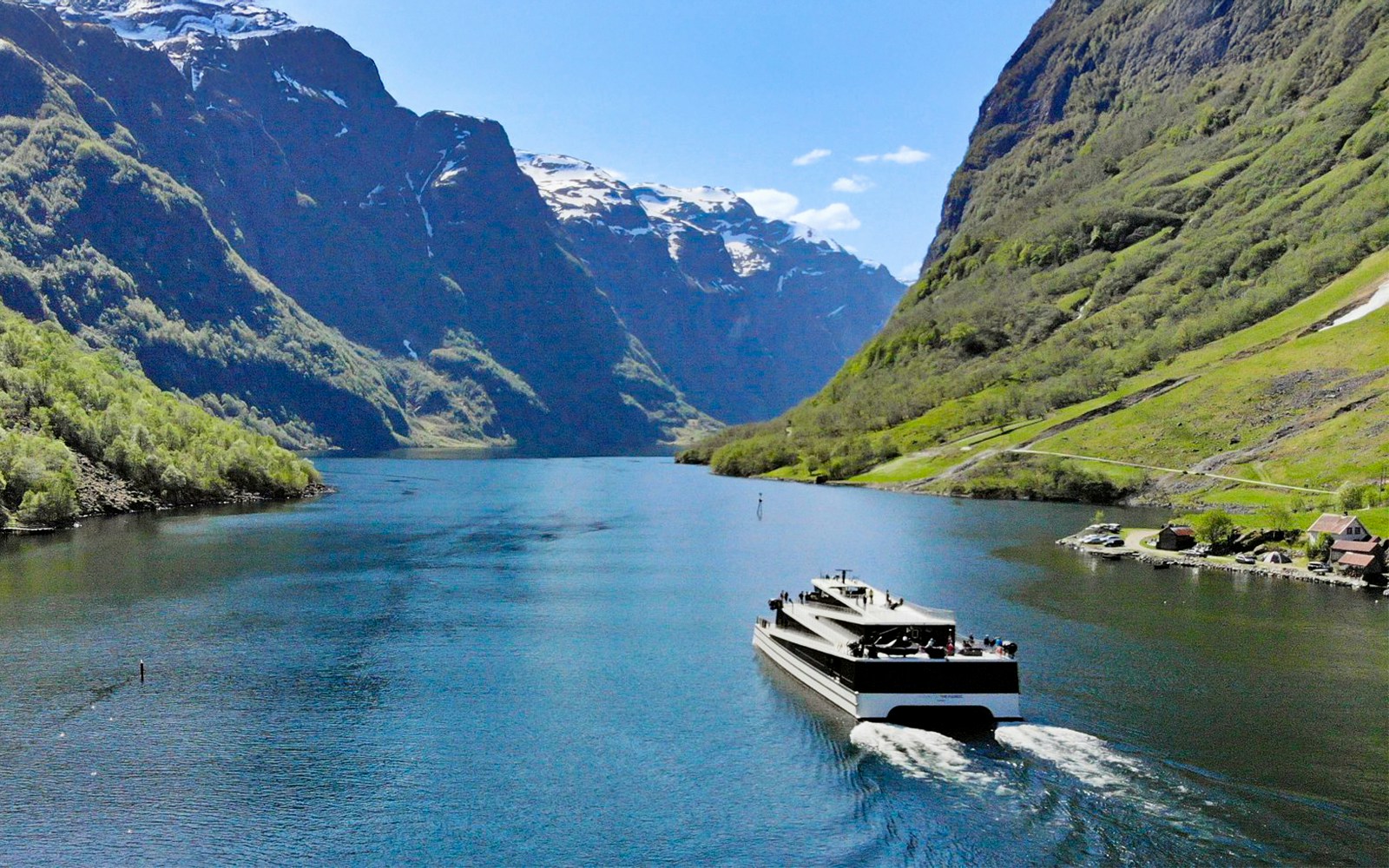 Cruise ship on Nærøyfjord surrounded by steep mountains, Norway.