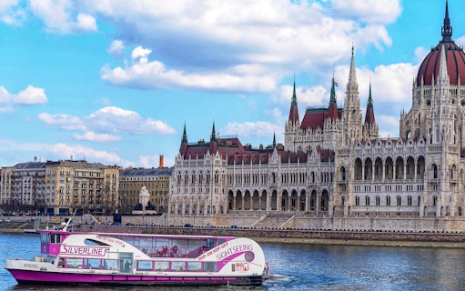 Cruise boat on the Danube River with Budapest Parliament in the background.