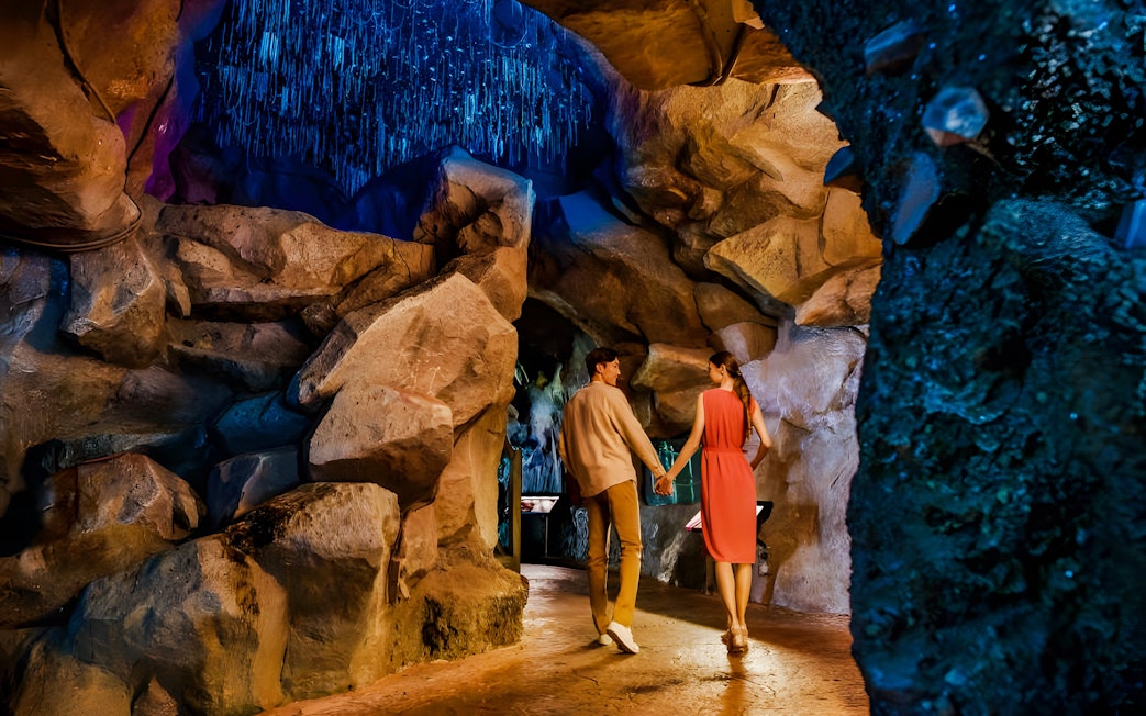 Couple exploring cave at Night Safari, Mandai Wildlife Reserve.