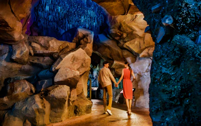 Couple exploring cave at Night Safari, Mandai Wildlife Reserve.