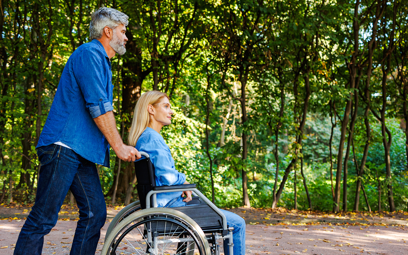 Man pushing woman in wheelchair along Jardin Secret path.