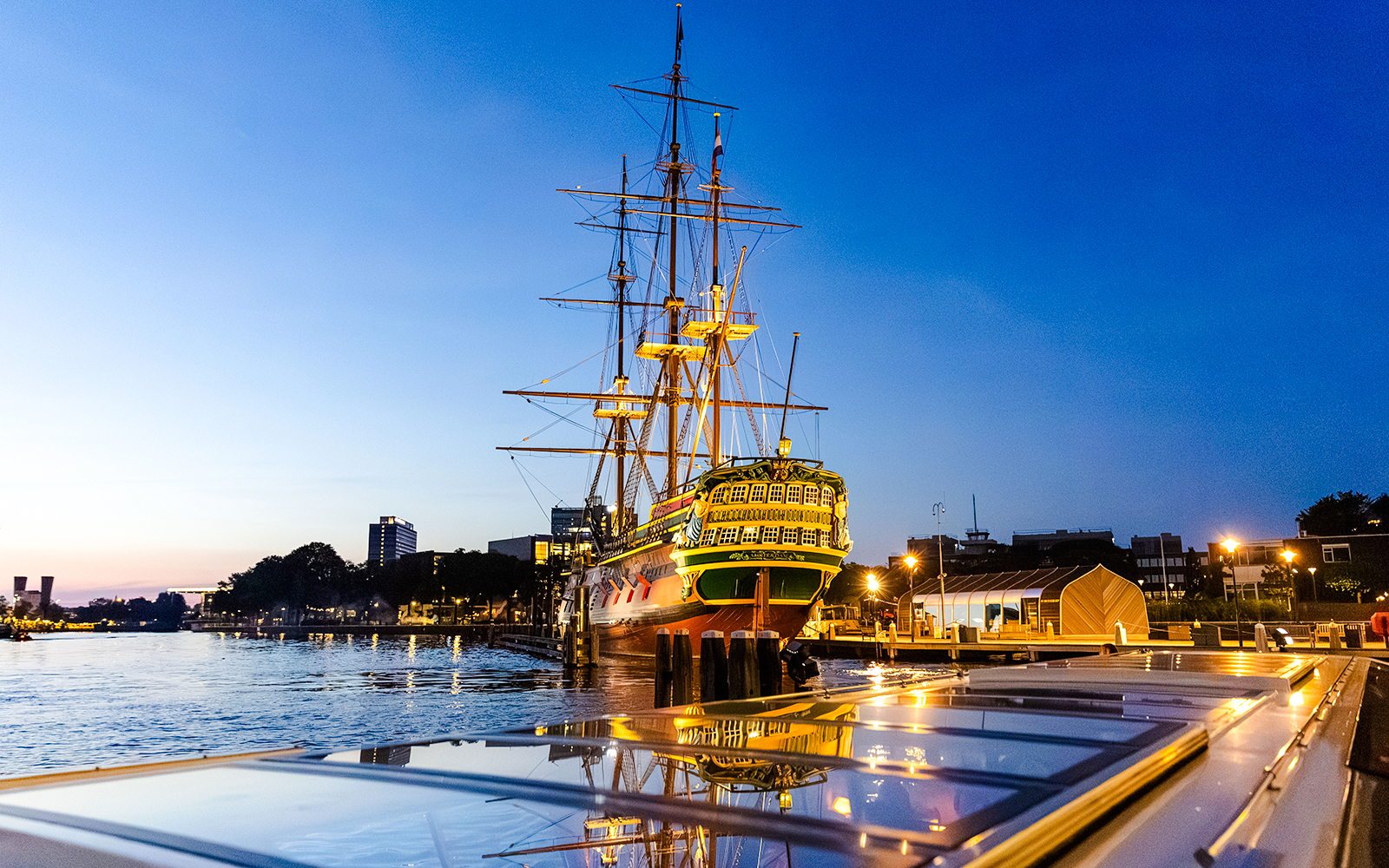 Maritime museum ship illuminated at dusk during Amsterdam Winter Evening Cruise.