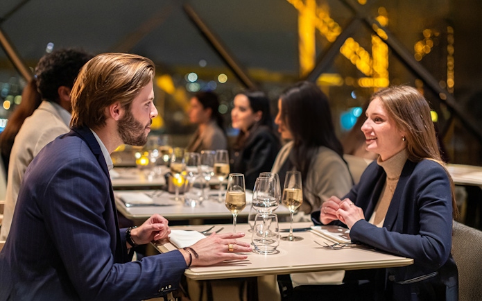 Young couple dining at Madame Brasserie Restaurant with Eiffel Tower view.