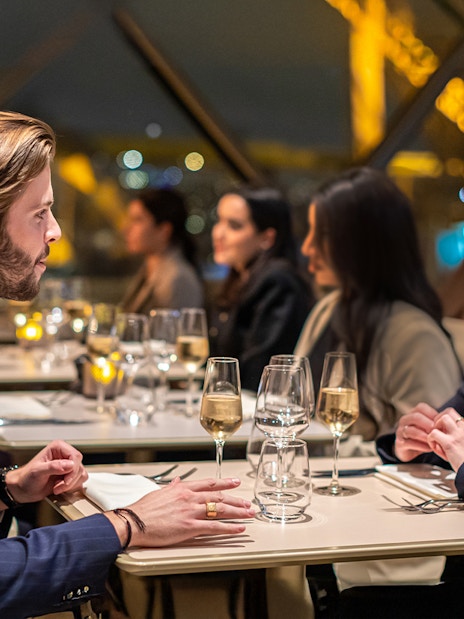 Young couple dining at Madame Brasserie Restaurant with Eiffel Tower view.