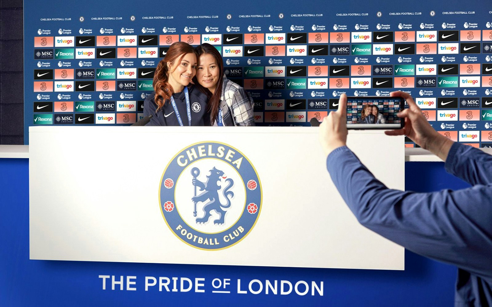 Chelsea FC press room with visitors posing for a photo during stadium tour.