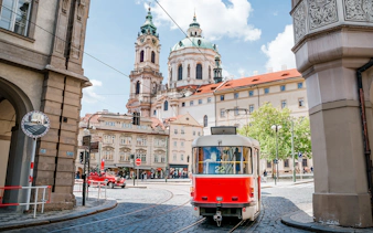 Tram passing near St. Nicholas Church in Prague during a guided tour.