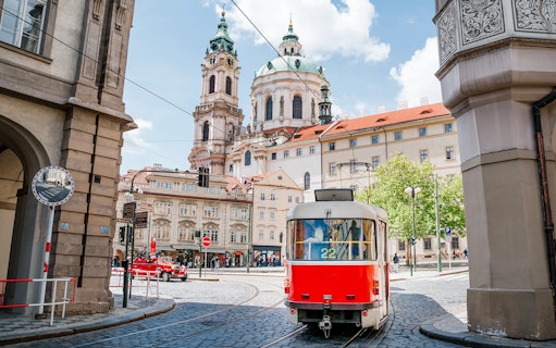 Tram passing near St. Nicholas Church in Prague during a guided tour.