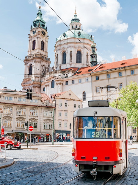 Tram passing near St. Nicholas Church in Prague during a guided tour.