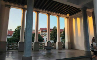 Colonnade with sunset light in Ljubljana, part of self-guided city exploration game.