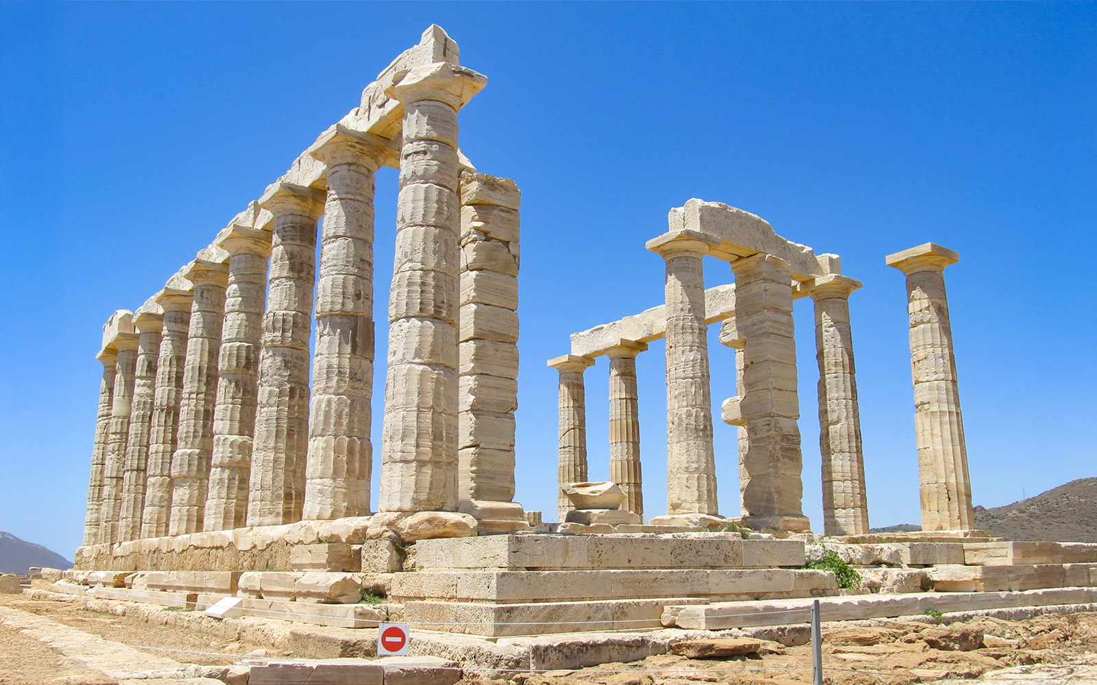 Temple of Poseidon columns at Cape Sounio under clear blue sky.