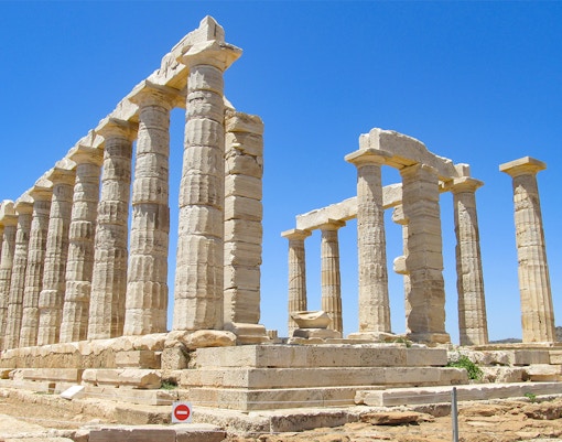 Temple of Poseidon columns at Cape Sounio under clear blue sky.