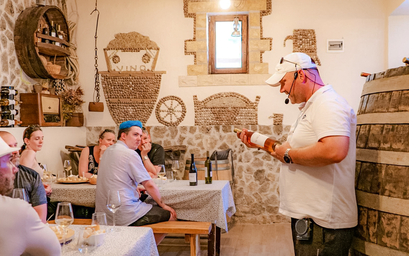 Tour guide explaining wine details to visitors at Krka National Park tasting room.
