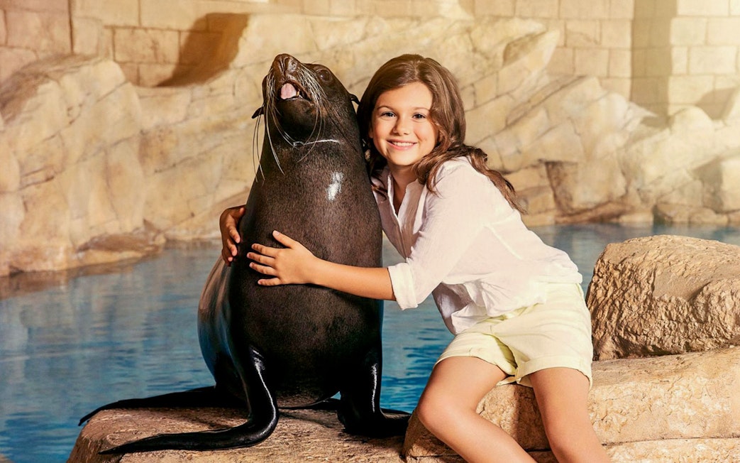 Girl hugging sea lion at Aquaventure Waterpark.