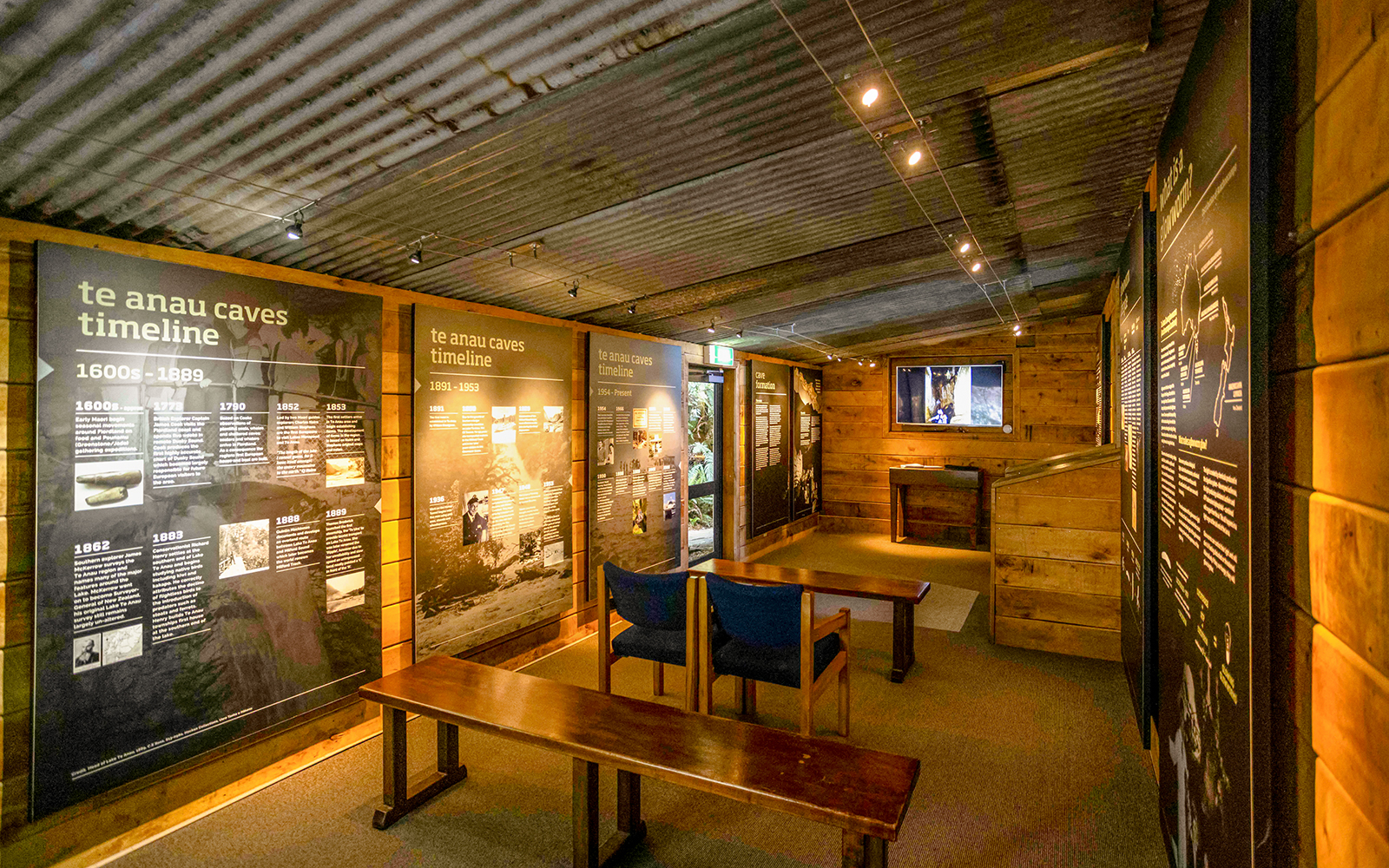 Te Anau Caves exhibit room with timeline displays and seating area.