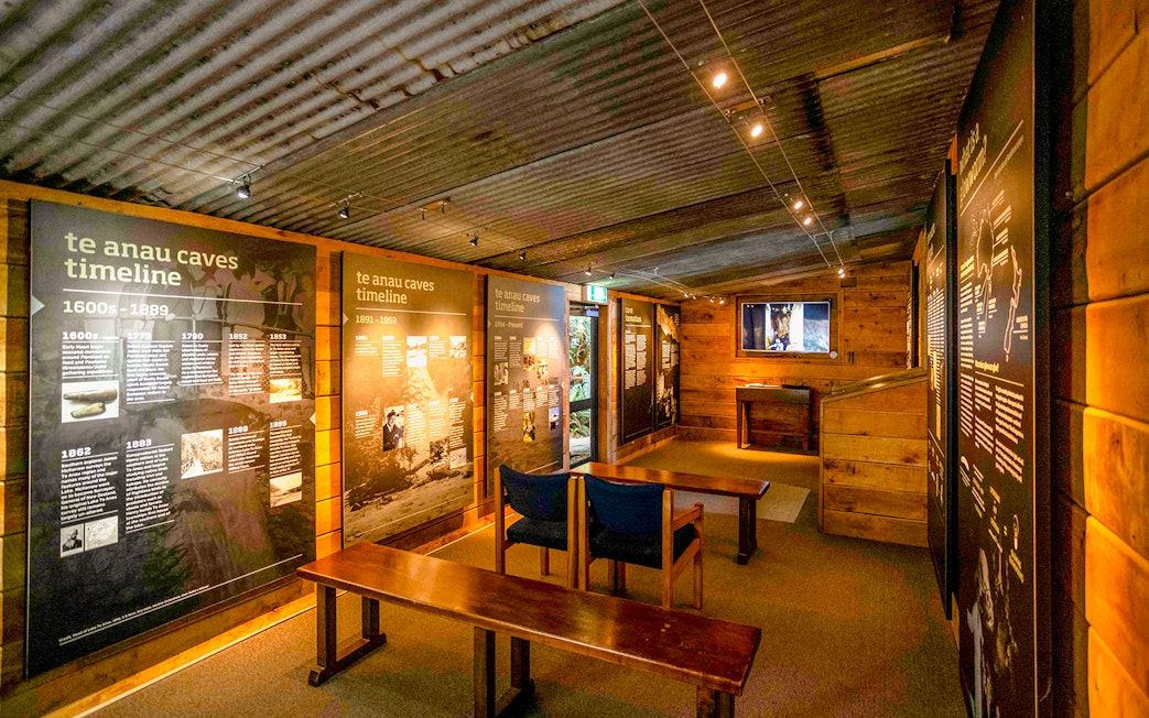 Te Anau Caves exhibit room with timeline displays and seating area.