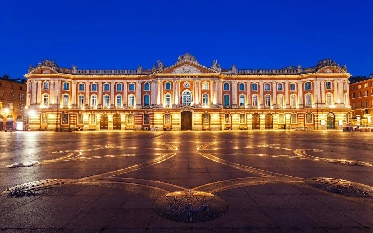 Capitole de Toulouse illuminated at night, central square view.