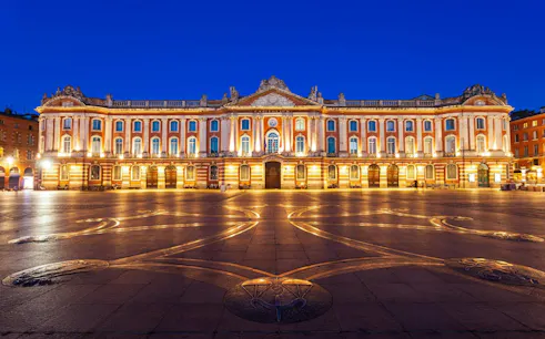 Capitole de Toulouse illuminated at night, central square view.