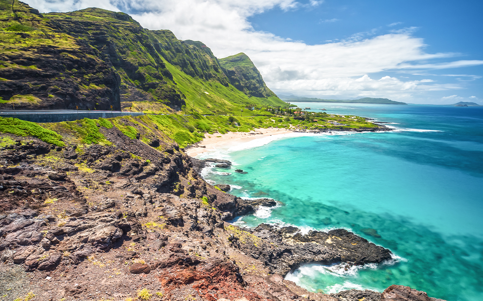 Hikers enjoying the view from Makapu'u Point Lookout, Oahu, Hawaii, overlooking the ocean and rugged coastline.
