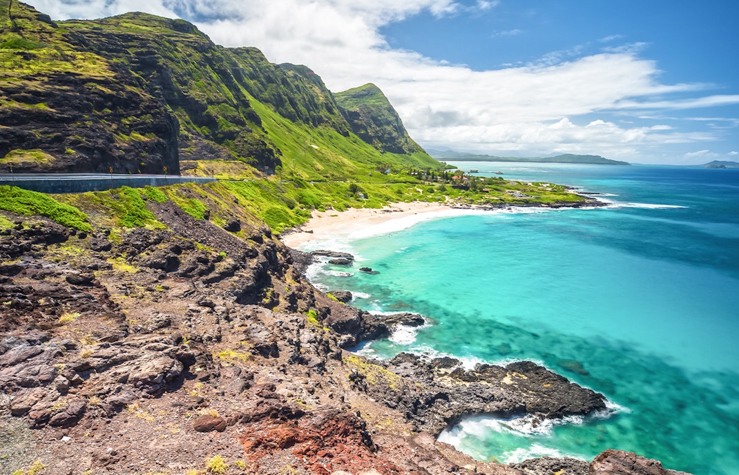 Hikers enjoying the view from Makapu'u Point Lookout, Oahu, Hawaii, overlooking the ocean and rugged coastline.