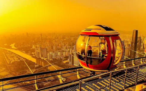 Bubble Tram on Canton Tower overlooking Guangzhou cityscape at 450 meters altitude.