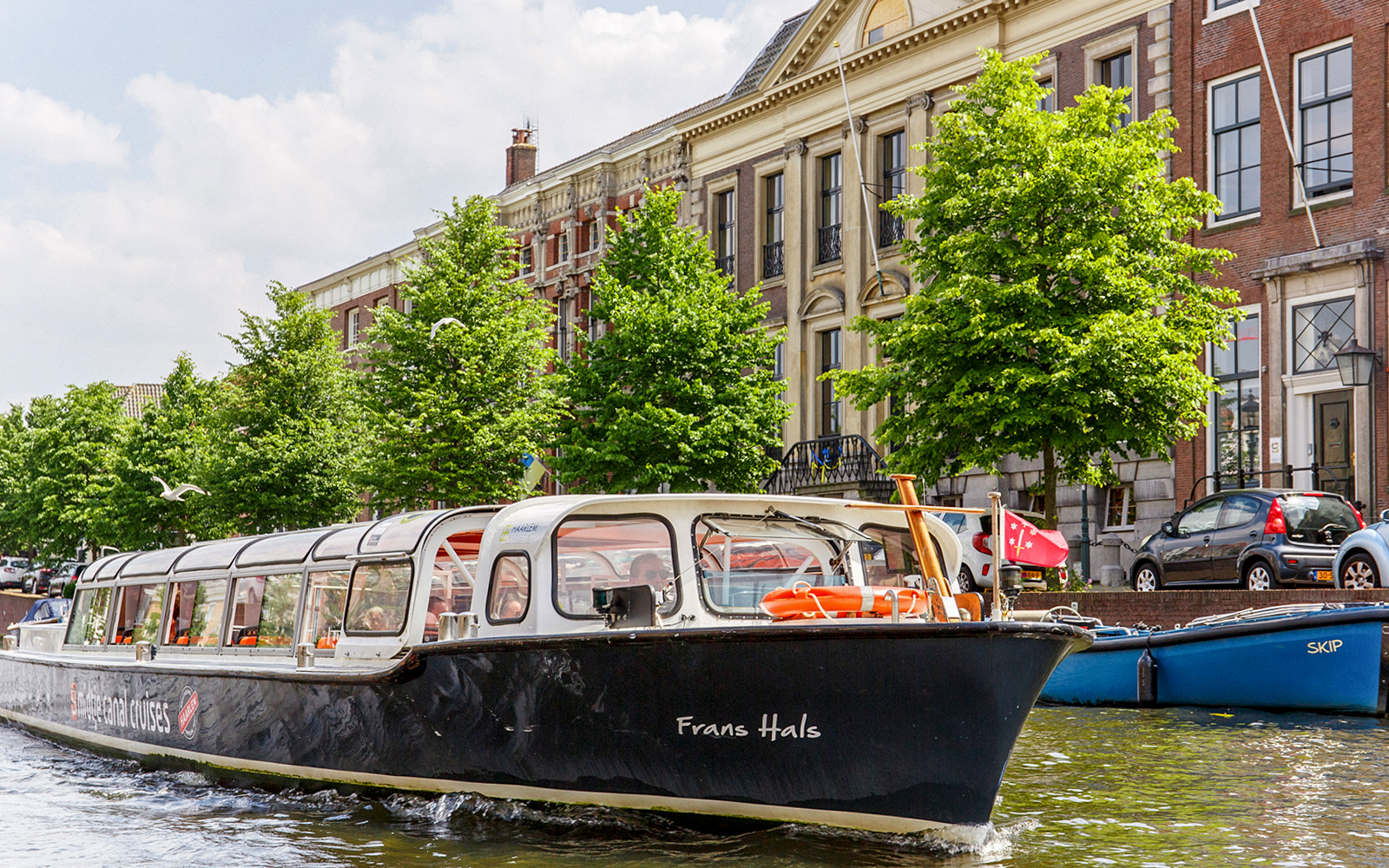 Canal boat cruising past historic buildings in Haarlem.