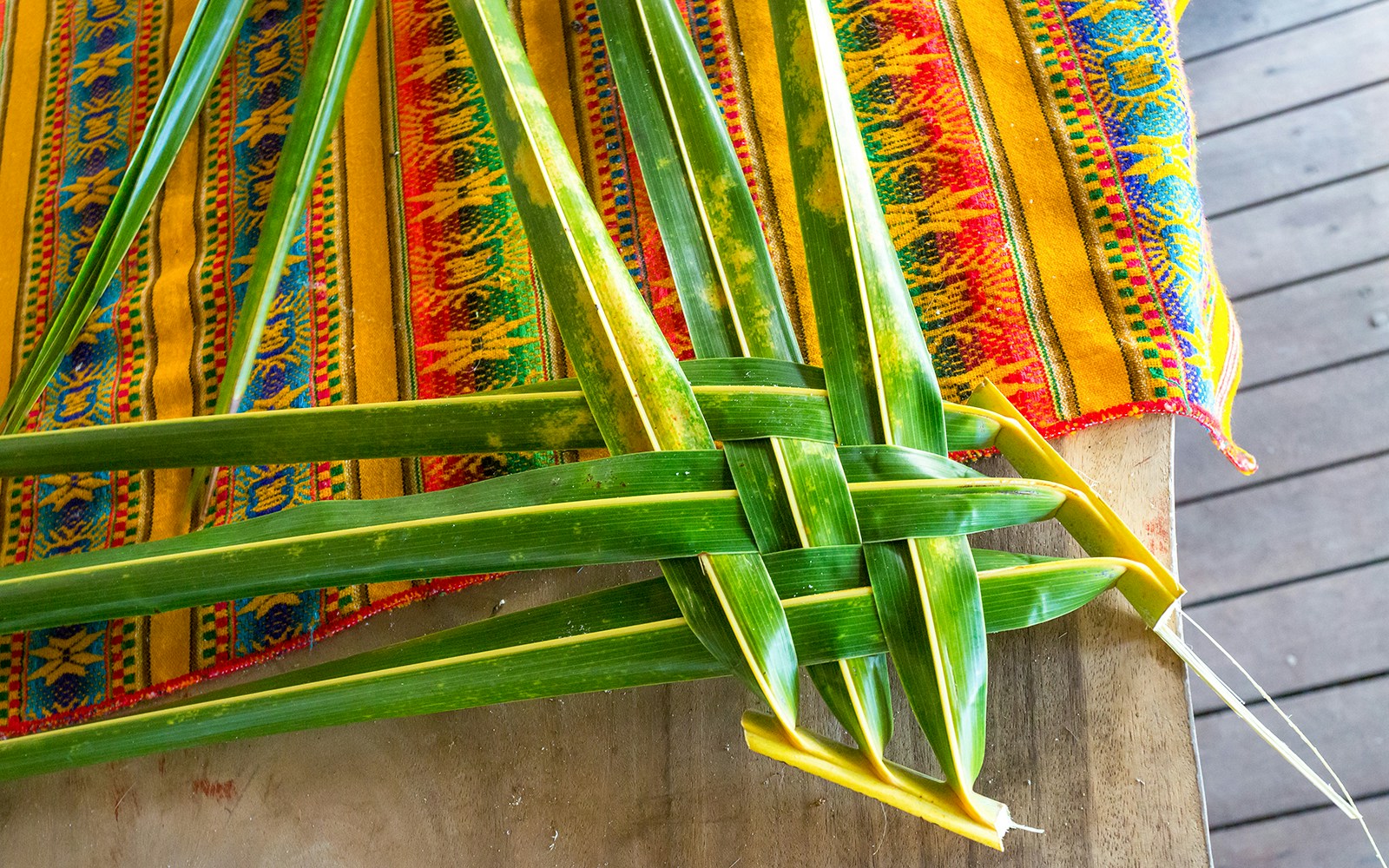 Woven palm leaves on colorful fabric, Kauai handicrafts.