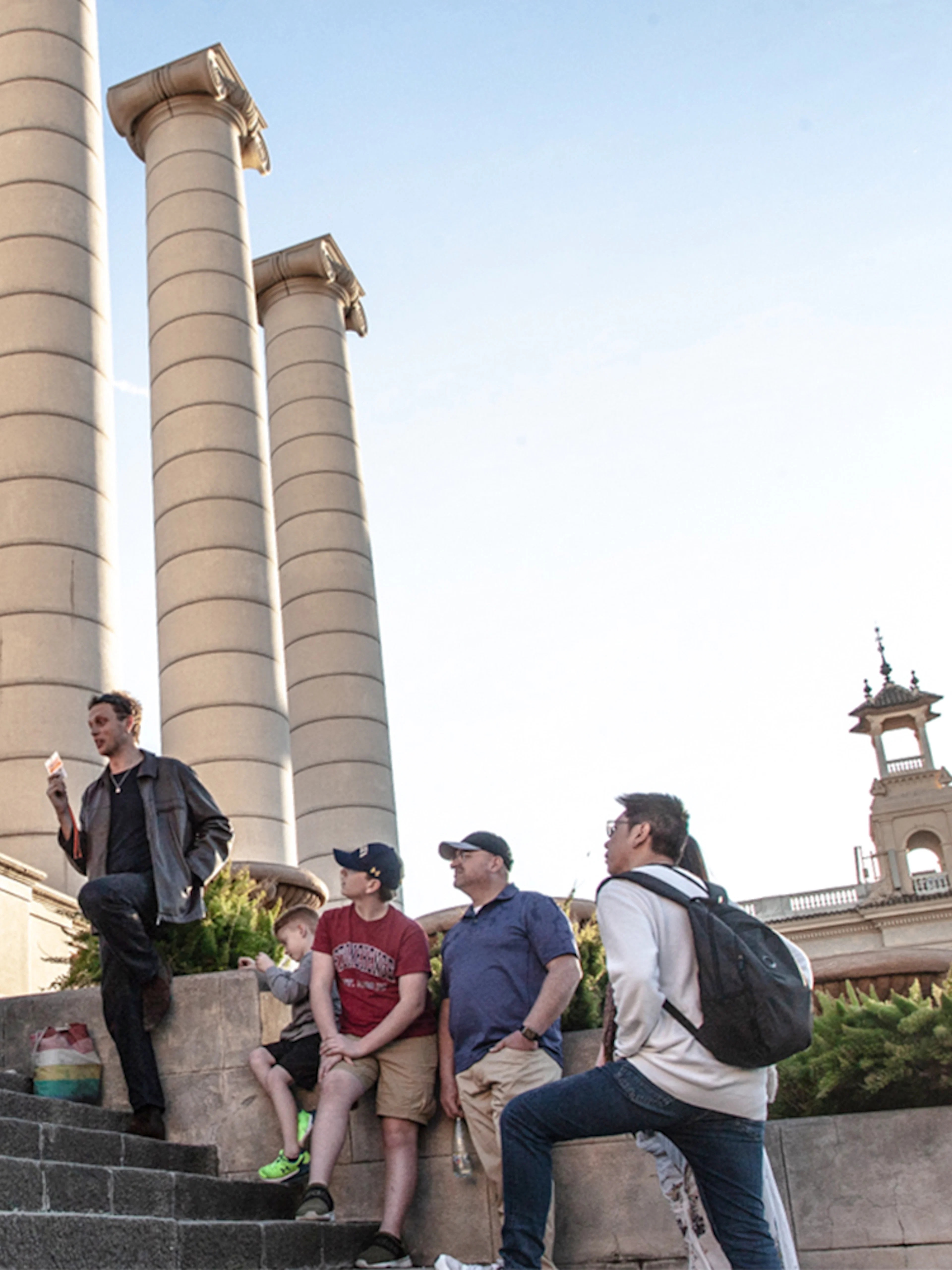 Group listening to a guide near Montjuïc columns in Barcelona.