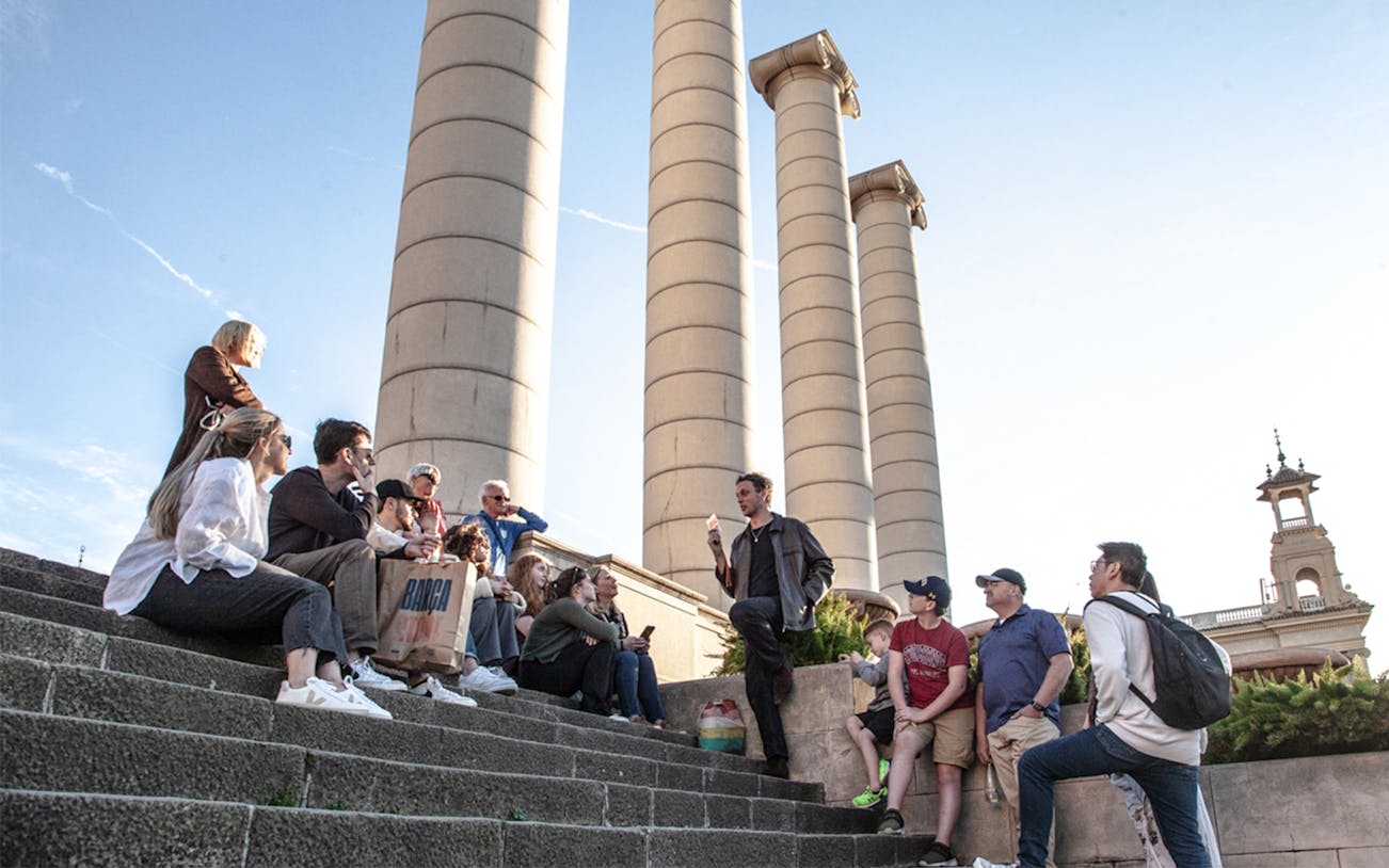 Group listening to a guide near Montjuïc columns in Barcelona.
