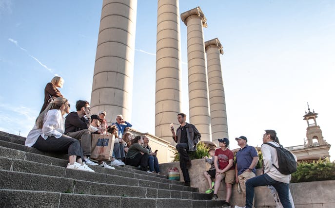 Group listening to a guide near Montjuïc columns in Barcelona.