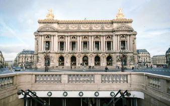 Opéra Garnier facade in Paris with street view and entrance steps.