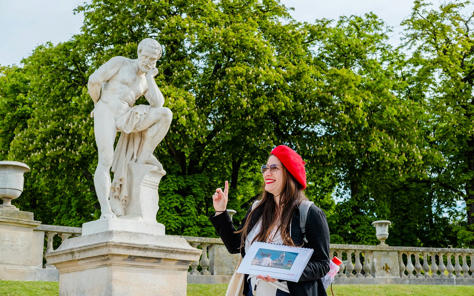 Guide pointing at a sculpture during Emily in Paris Locations Walking Tour.