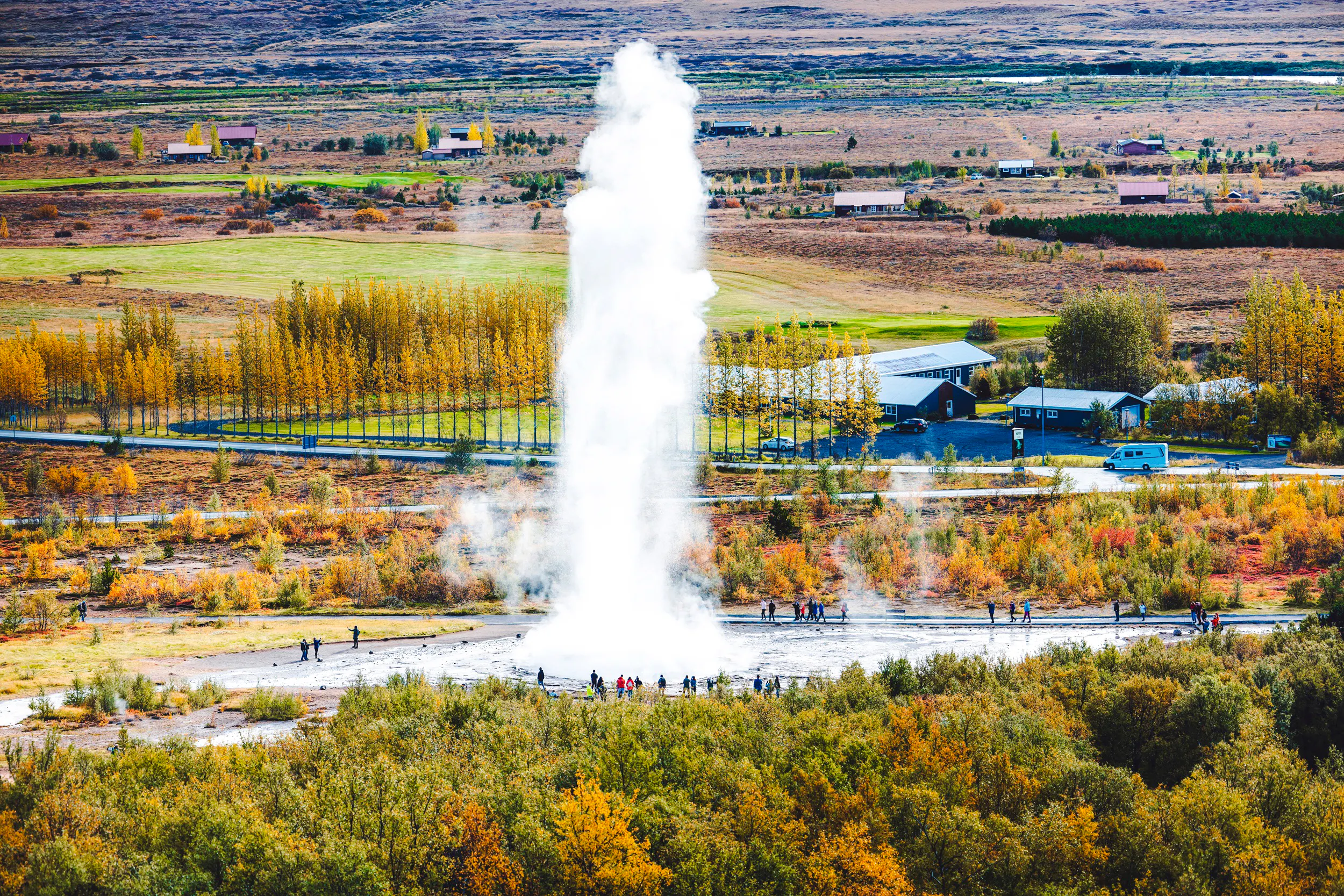 Geyser eruption in Iceland's Golden Circle with tourists nearby, part of Reykjavik day tour.