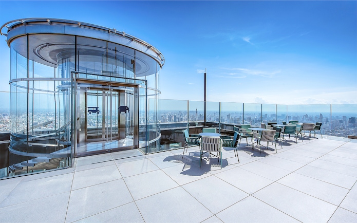 Mahanakhon SkyWalk glass elevator and observation deck with city view in Bangkok, Thailand.