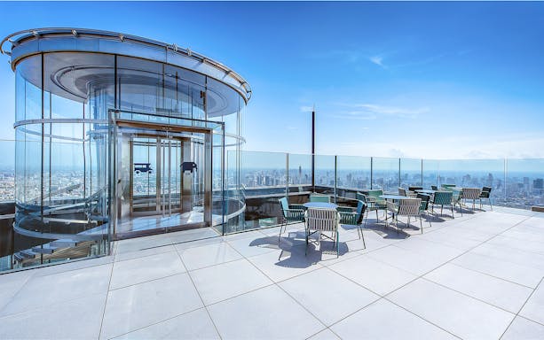 Mahanakhon SkyWalk glass elevator and observation deck with city view in Bangkok, Thailand.