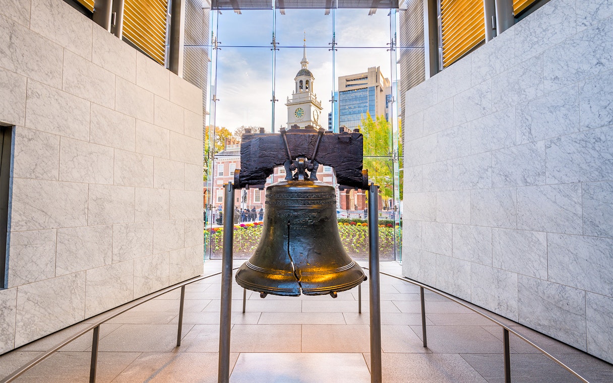 Liberty Bell with Independence Hall in Philadelphia background.