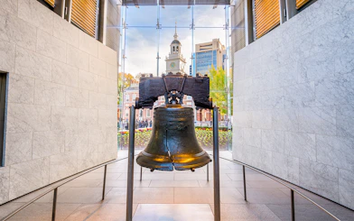 Liberty Bell with Independence Hall in Philadelphia background.