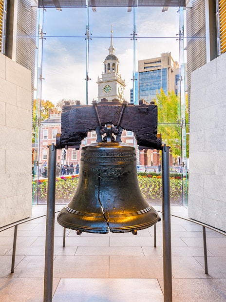 Liberty Bell with Independence Hall in Philadelphia background.