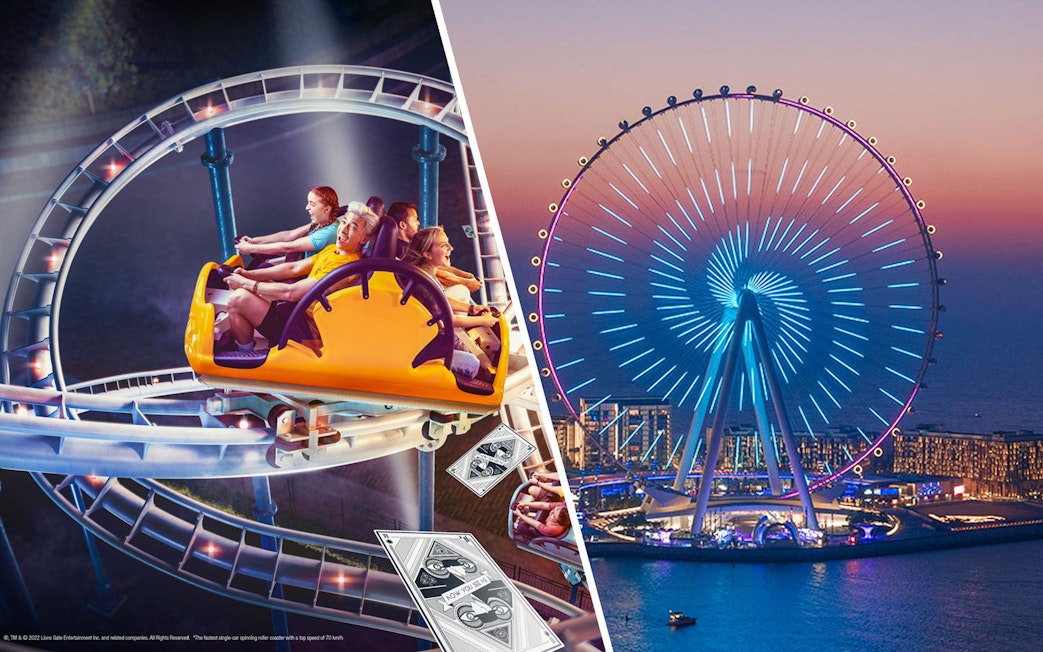 Ain Dubai illuminated at night with a roller coaster ride in the foreground.