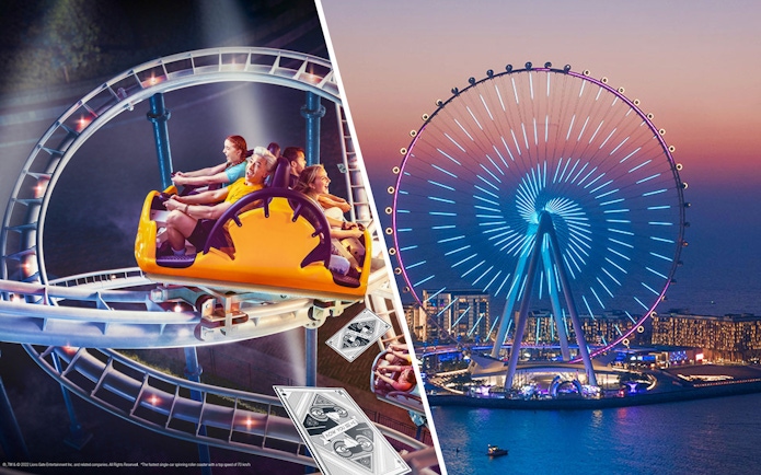 Ain Dubai illuminated at night with a roller coaster ride in the foreground.