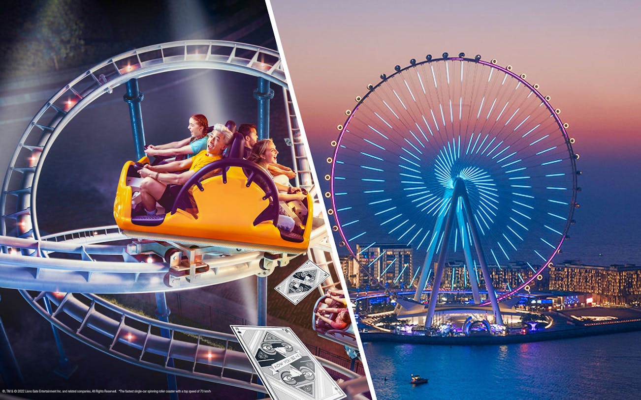 Ain Dubai illuminated at night with a roller coaster ride in the foreground.