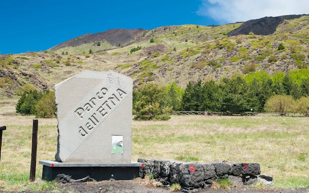 Parco dell'Etna sign with Mount Etna's south side in the background.